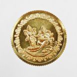 A Tanishq gold coin, depicting two Hindu figures, stamped 995 fine gold, 10g, in presentation sleeve