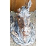A concrete wall mounted horse's head garden ornament, later painted in brown and black, one ear