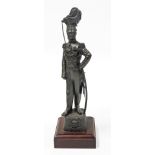 A bronze patinated regimental resin figure of an officer of the 17th/21st Lancers, on a wooden