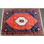 A Turkish design rug, central cream medallion with flames and birds, on a red and blue ground with