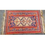 A Persian type carpet, with central three medallion design, in red, orange, blue and cream, with