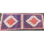 An Eastern Kilim rug, with central staggered medallion, on a red ground with outer three medallions,