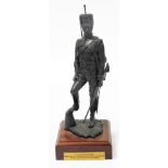 A bronze painted regimental resin figure of a sergeant of 11th Hussars c1890, on a wooden plinth,