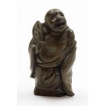 An oriental bronzed metal figure of a buddha, modelled holding a fan, 8cm high.