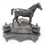 A bronze desk stand mounted as a standing horse, on a rustic stand incorporating two ink recesses