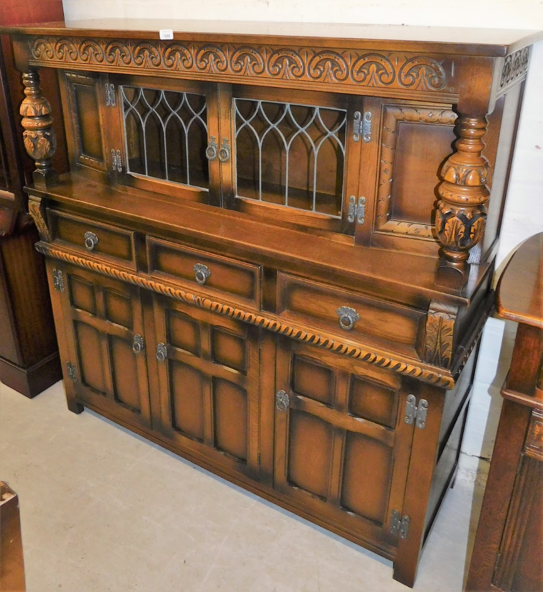 An Old Charm oak finish court cupboard, the carved oak top and baluster with display cabinet top,