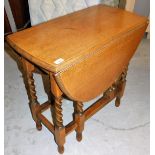 A 20thC oak drop leaf table, the barley twist legs on reeded support ends, 74cm high, 107cm wide