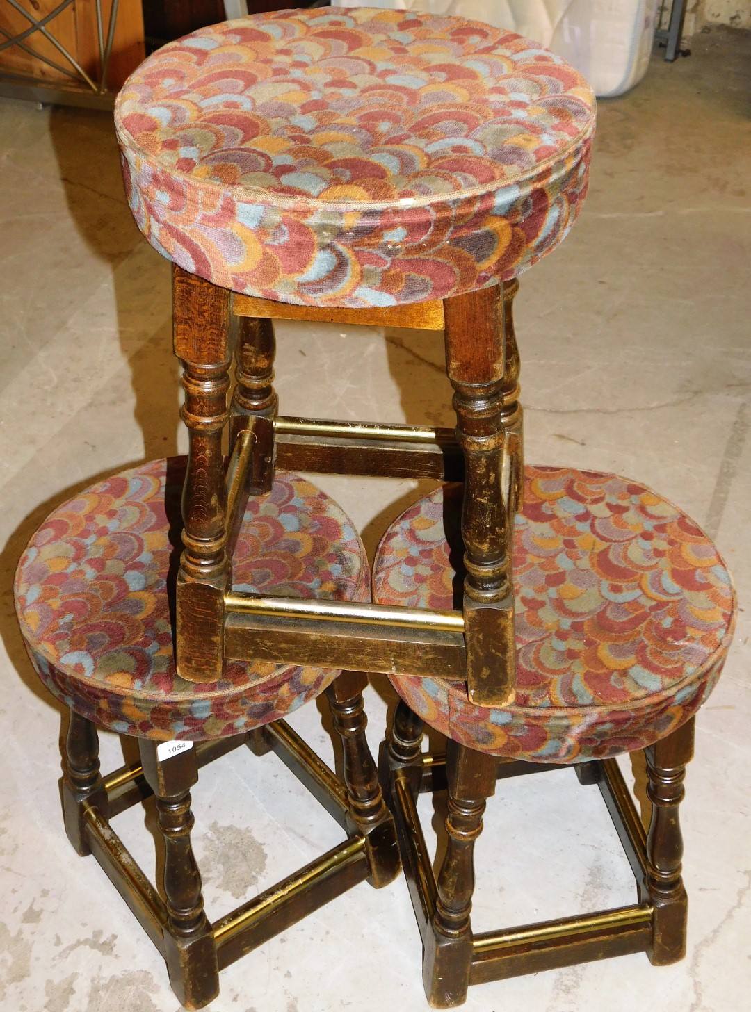 *Three framed pub stools, each with floral upholstered tops on wooden base,with brass bars, 52cm
