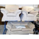 A two seater sofa and two matching armchairs, in a cream coloured upholstery, the two seater sofa