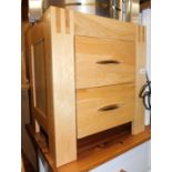 A blonde oak two drawer bedside chest, 53cm high, 48cm wide, 38cm deep.