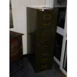 An early 20thC green steel filing cabinet, with brass handles and card holders, lacking key.