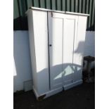 A Victorian pine wardrobe, in two sections with single door, painted white, raised on a plinth base,