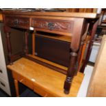 A mahogany two drawer side table, with carved drawer fronts, raised on turned legs, 70cm high,