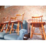 A set of four stained pine spindleback kitchen chairs.