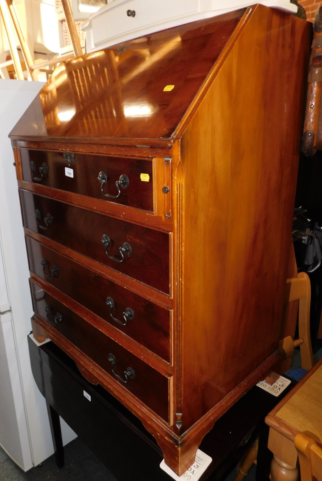 A yew wood bureau with fitted interior, above four drawers, 100cm high, 74cm wide, 47cm deep.