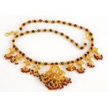 An Indian costume jewellery necklace, the red beaded necklace chain, with four drop sections each