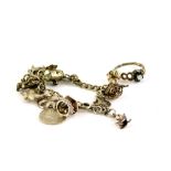 A silver charm bracelet and dress ring, the charm bracelet with various charms including three