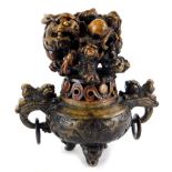 An oriental stained soapstone Koro, decorated with a dragon, the base with two ring handles, etc.