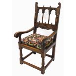 An oak throne type chair in 17thC style, the back with spindle turned and leaf carved arches,