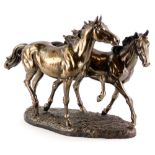 A bronze effect resin model of two horses, mounted on an oval base, 44cm wide.