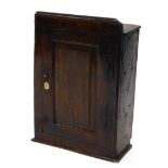 A late 17th/early 18thC oak wall cupboard, the top with a moulded edge above a single panelled door,
