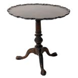 A mahogany occasional table in George III style, the circular pie crust top, on a reeded leaf carved