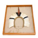 A tribal headdress, with central red feather, and black and white feather, etc., framed, (possibly
