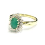 An emerald and diamond dress ring, set with oval cut emerald and diamonds, the emerald totalling 1.