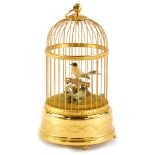 A 20thC Swiss musical bird cage, containing two feather clad birds, on the base decorated with