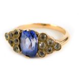An Art Deco style ring, with oval cut pale blue sapphire, flanked by triangle staggered design set