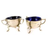 A pair of Edward VII silver salts, of cylindrical form with three stylised handles and an engraved