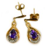 A pair of amethyst drop earrings, each set with a tear drop cut stone and various tiny diamonds,