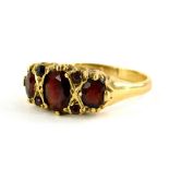 A 9ct gold garnet set dress ring, with three large oval cut garnets, dispersed with four tiny