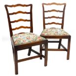 A pair of early 19thC oak side chairs, each with a shaped ladder back, drop in seat, on chamfered