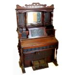 A late 19thC Canadian walnut harmonium, the elaborate raised back with a central bevelled mirror