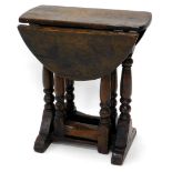 A small oak drop leaf table in 17thC style, the oval top on turned end supports with gateleg and