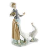 A Lladro porcelain figure, of a young girl with a goose, (AF), and a Lladro goose. (2)