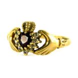 A 9ct gold Claddagh dress ring, with heart shaped central garnet stones, surrounded by white