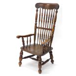 A 19thC ash and elm Windsor armchair, with a spindle turned back, shaped arms and solid seat, on