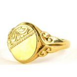 A 9ct gold signet ring, the oval shield with partial engraved decoration, on two splay scroll