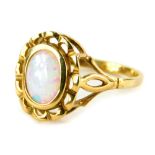 A 9ct gold opal dress ring, the oval opal in a rub over setting, with pierced design, gold metal