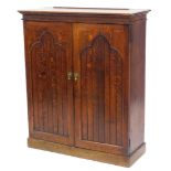 An early 20thC oak side cabinet in Arts and Crafts style, with two panelled doors, enclosing a