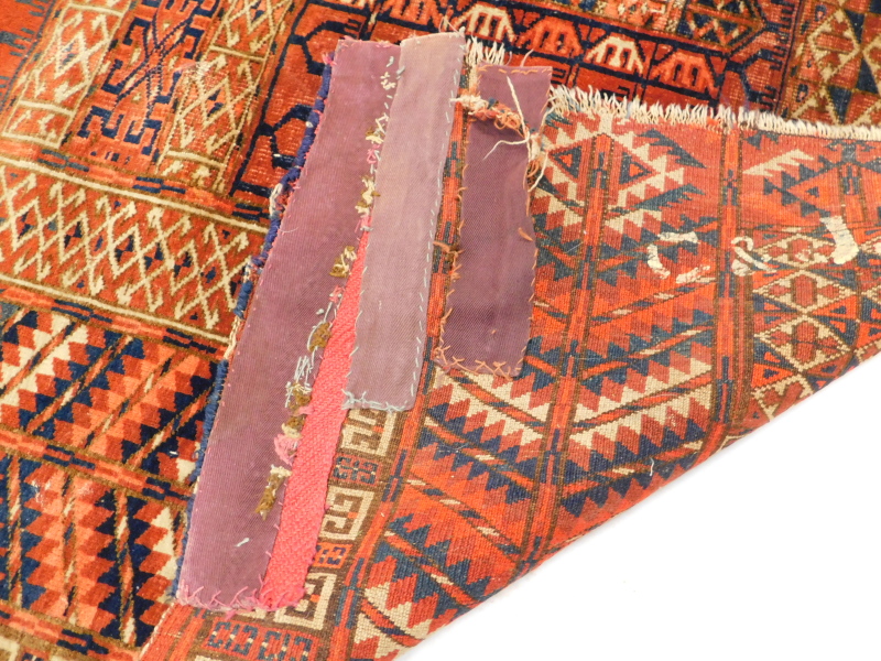 A Turkoman type rug, with a geometric design in navy blue, red, etc., on a red ground with - Image 3 of 3