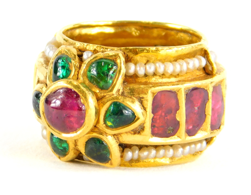 An Indian dress ring, set with various cabochon cut rubies, emeralds and seed pearls, the centre