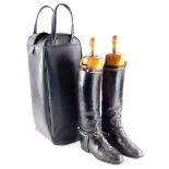 A pair of black leather riding boots, with trees in a black leatherette travelling case.