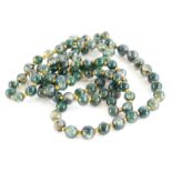 A jadeite graduated beaded necklace, each bead of pale colour with dark green splashes, on string,