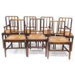 A set of seven early 19thC oak dining chairs, each with a rail back, a woven drop in seat, on square