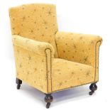 An Edwardian child's armchair, upholstered in gold fabric with star design on bun feet, with metal