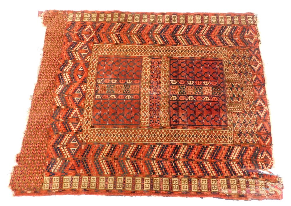 A Turkoman type rug, with a geometric design in navy blue, red, etc., on a red ground with