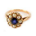 A sapphire and seed pearl daisy ring, the central oval cut sapphire surrounded by seed pearls, in
